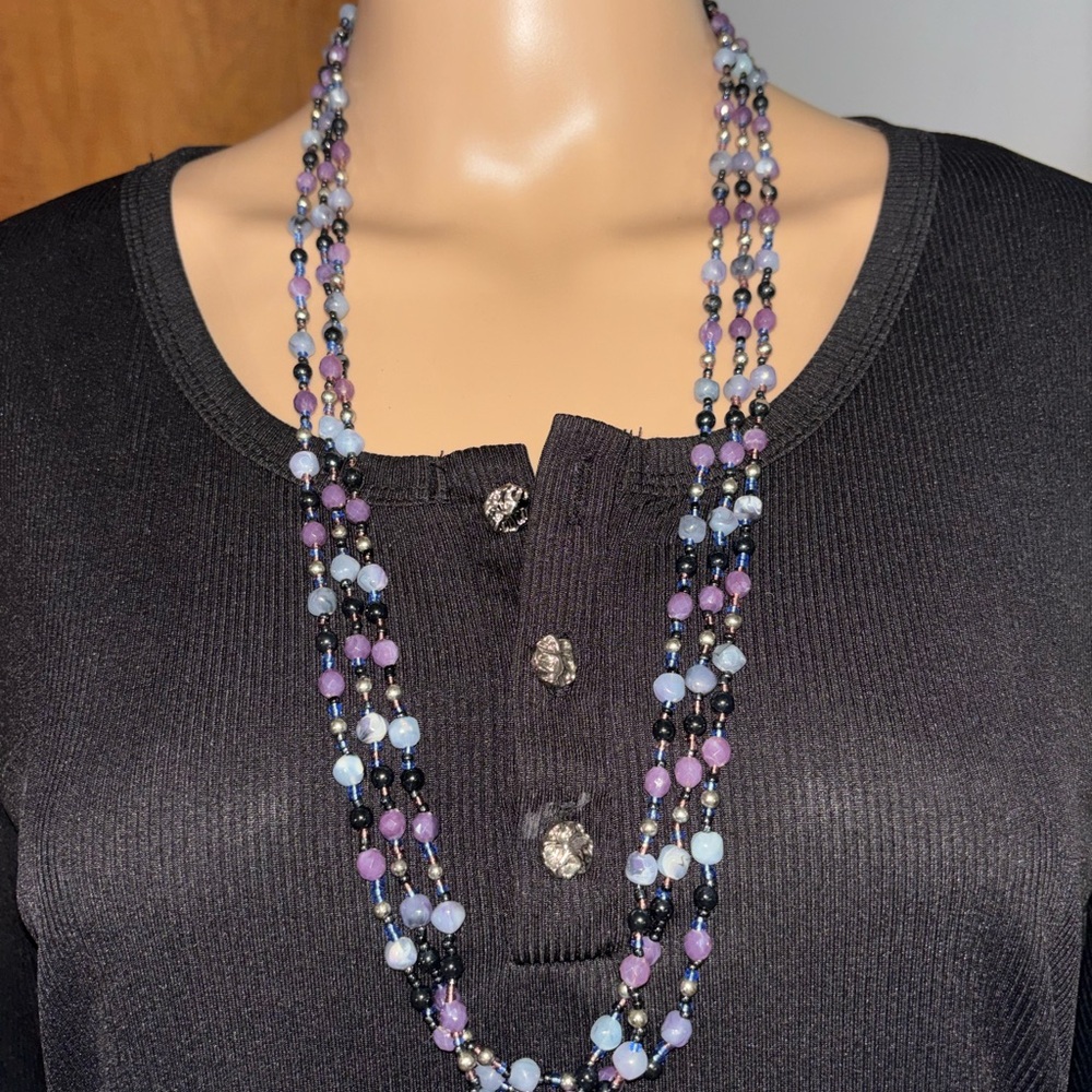 multi-strand glass beaded necklace featuring purple, white, and black beads.